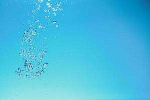 Abstract background image of bubbles in water. Clean water with water droplets and waves. Fresh water a glass with bubbles blue background. photo