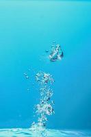 Abstract background image of bubbles in water. Clean water with water droplets and waves. Fresh water a glass with bubbles blue background. photo