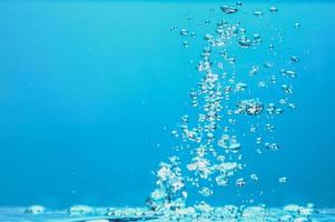 Abstract background image of bubbles in water. Clean water with water droplets and waves. Fresh water a glass with bubbles blue background. photo