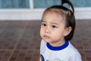 Portrait of an adorable little pensive girl looking for someone or something. Pretty small girl looking up at mother.Childhood and family concept photo