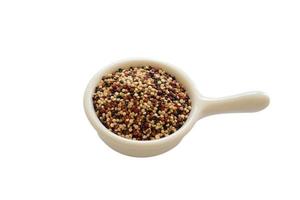 Quinoa seeds in the white cup isolated on white background.  Quinoa is a good source of protein for people following a plant-based diet. photo