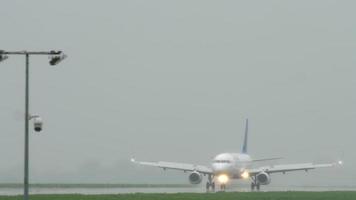 Air Astana Airbus 320 taxiing after landing in the rain. video