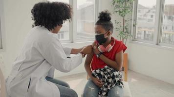 médico afroamericano está aplicando yeso en el hombro de un niño después de ser vacunado. abrir mangas para vacunar contra la gripe o la epidemia en la atención de la salud y el concepto de vacunación.