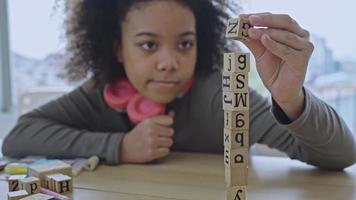 afro-amerikaanse student doet activiteit blok houten spelen voor ontwikkeling samen met genieten en plezier in de klas. video