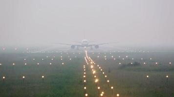 avión gira en la pista de aterrizaje en niebla espesa