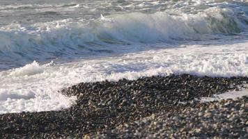 olas del mar rodando hacia la playa de guijarros video