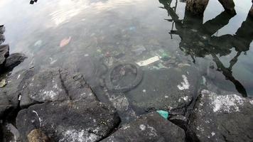 Panning fish eye view of rubbish in the sea water video