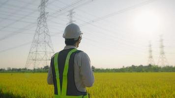 engenheiros elétricos relatam uma inspeção de postes de alta tensão antes de iniciar um projeto.