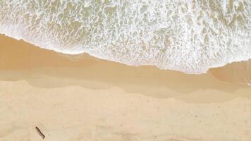 Zoom in aerial view of sand beach and water surface texture. Foamy waves with sky. Beautiful tropical beach. Amazing Sandy coastline with white sea waves. Nature, seascape and summer concept. video