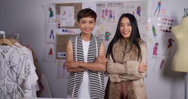 Portrait of Two Asian smiling attractive woman standing and looking at camera in office. Happy business woman designer look at camera. Fashion designer and entrepreneur concept. video