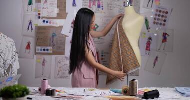 Happy Young Asian fashion designer woman measuring tape on mannequin model in studio. SME marketing and entrepreneur concept. video