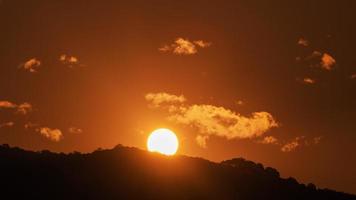 timelapse van dramatische zonsondergang met oranje lucht in een zonnige dag.