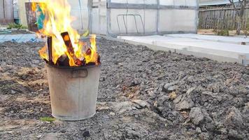 Garbage burns in a metal tank in the garden video