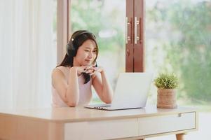 woman wear headphones video conference on laptop photo