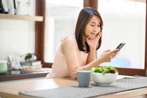 woman using smartphone mobile at home in kitchen photo