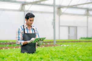 agricultor que usa una tableta digital para controlar el sistema agrícola foto