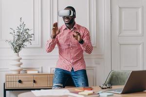 African man in VR headset interacting with digital interface, using innovative device for business photo