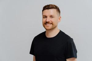 Handsome redhead man feeling happy and expressing positivity photo