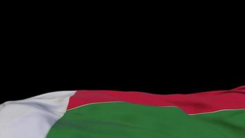 bandeira de tecido de madagascar acenando no loop de vento. madagascar bordado bandeira de pano costurada balançando na brisa. fundo preto meio preenchido. lugar para texto. Ciclo de 20 segundos. video