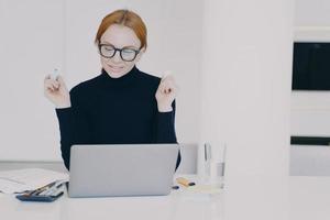 Confident female entrepreneur woman in office is doing paperwork with marker pen highlighting text. photo