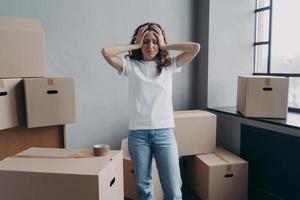 Exhausted woman is tired from packing cardboard boxes with duct tape. Anxiety and stress. photo