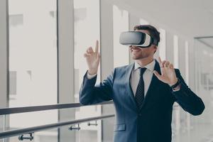 Handsome smiling businessman in vr headset using innovative technologies for business at work photo