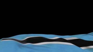 Botswana fabric flag waving on the wind loop. Botswana embroidery stiched cloth banner swaying on the breeze. Half-filled black background. Place for text. 20 seconds loop. 4k video