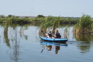 Couple of travelers swim in kayak on the river photo