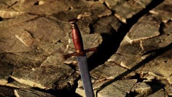 excalibur zwaard in rotsachtige steen bij zonsondergang video