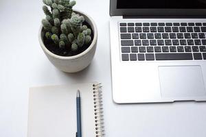 notebook on white table with gadgets and decorations, top view of writer, freelancer or buisinessman work place photo