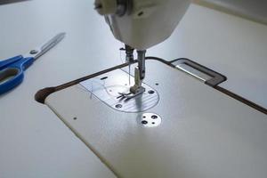máquina de coser en la mesa de trabajo en sastrería foto