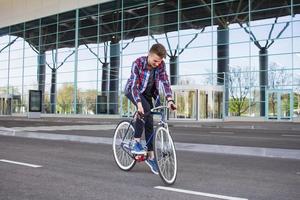 hombre ciclista montando bicicleta retro deportiva de piñón fijo. foto