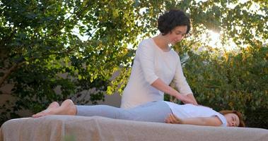 Woman do traditional chinese massage outdoors in summer garden photo
