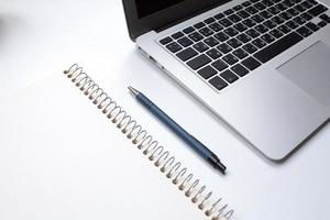 notebook on white table with gadgets and decorations, top view of writer, freelancer or buisinessman work place photo