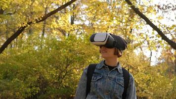 Happy Young Female With Virtual Reality Glasses having fun in autumn park photo