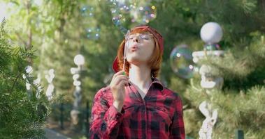 Young woman play with soap bubbles outdoors video