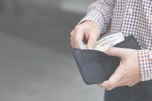 hombre con billetera negra llena de dinero foto