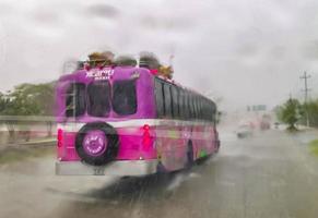 Playa del Carmen Quintana Roo Mexico 2022 Pink Xcaret bus drives in heavy rain on highway Mexico. photo