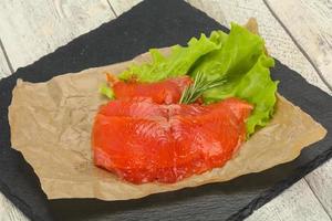 filete de salmón en rodajas servido con romero foto
