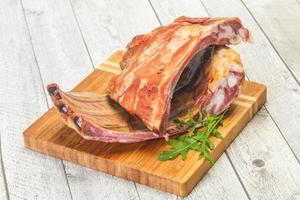 Smoked pork ribs over the wooden background photo