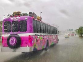 Playa del Carmen Quintana Roo Mexico 2022 Pink Xcaret bus drives in heavy rain on highway Mexico. photo