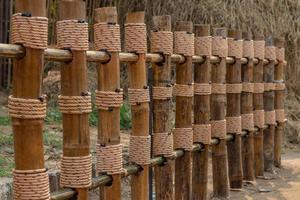 Fence of bamboo poles wrapped with rope. photo