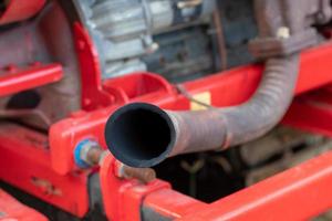 Old exhaust pipe with red combine harvester. photo