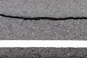 Asphalt road surface cracks near the white line. photo