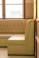 Old cream-colored sofa in the corner of the room with window light. photo