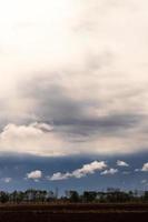 Clouds over the ground that were plowed in the early morning. photo