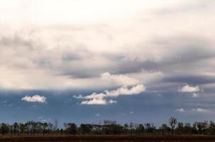 Clouds over the ground that were plowed in the early morning. photo