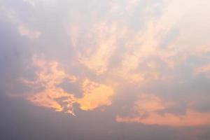 Orange light shining through the overcast clouds. photo