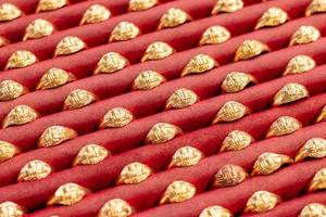 Many gold rings are placed on red fabrics. photo