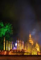 Old Buddhist temple at night with lights and smoke. photo